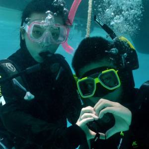 a man wearing sunglasses and swimming in the water