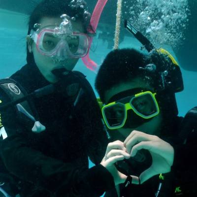 a man wearing sunglasses and swimming in the water