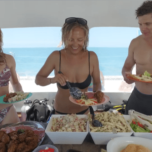 a group of people sitting at a table with a plate of food