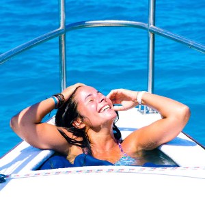 a woman sitting next to a body of water